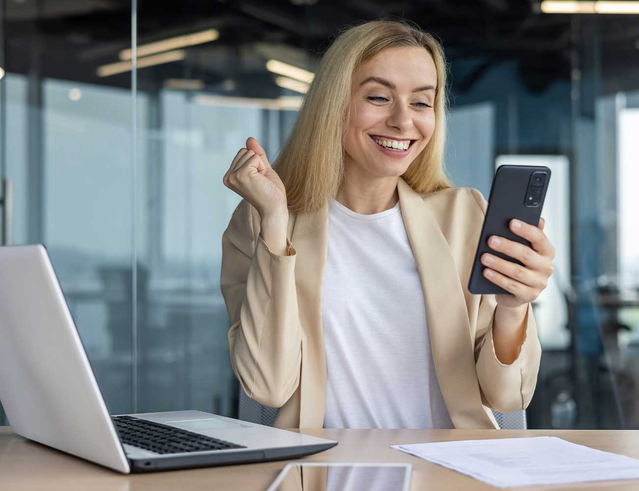 Woman joyfully looking at phone.